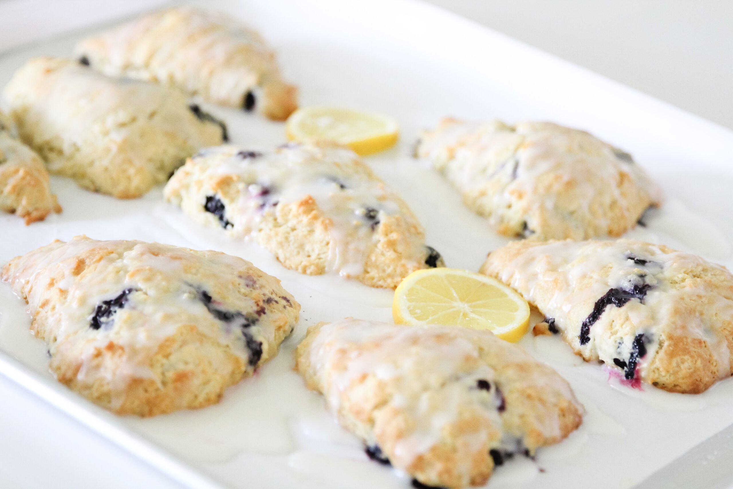 photo of glazed lemon blueberry scones and lemon slices as decoration